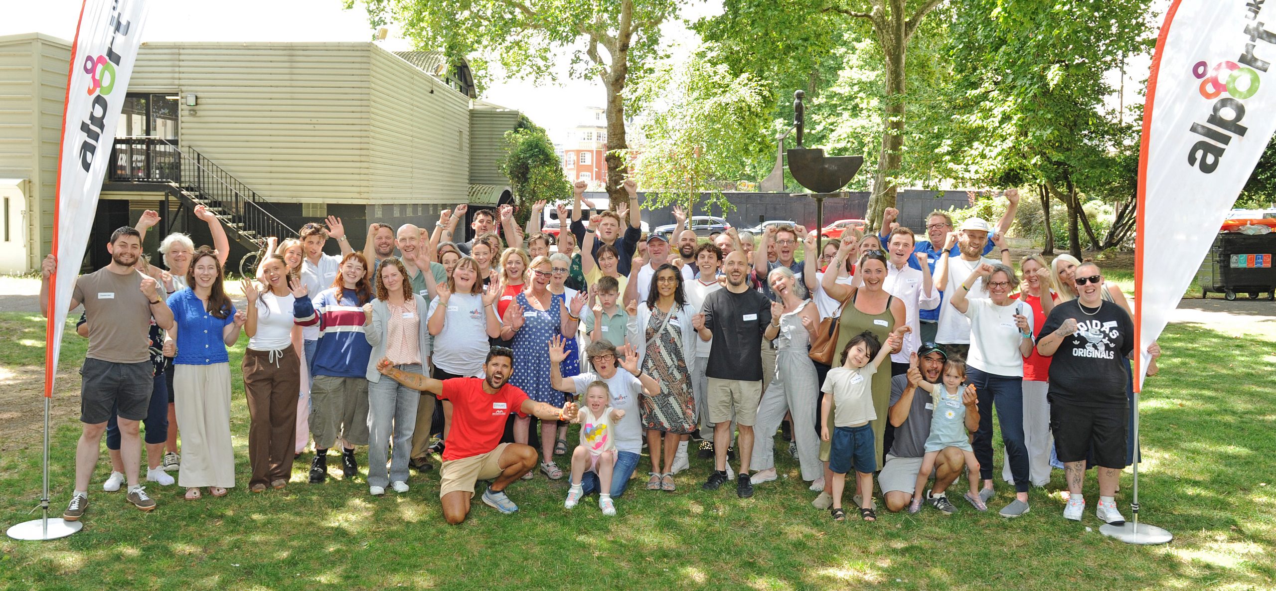 Group photo of attendees at the Alport UK Information Day on 4 July 2026, standing together outdoors and smiling between two Alport UK flags.