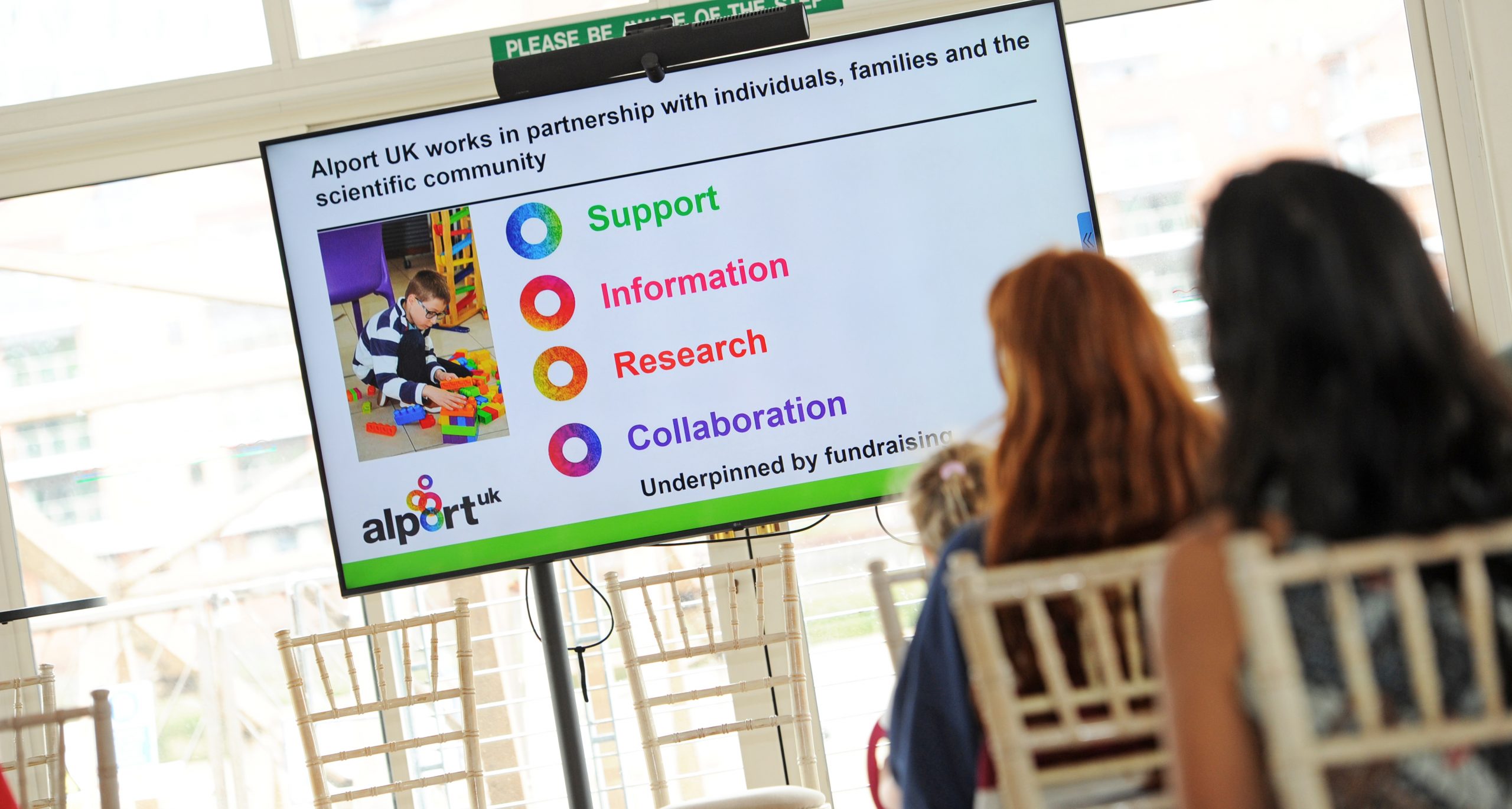 Presentation slide shown at the Alport UK Information Day explaining the charity's five key areas of work: support, information, research, collaboration and fundraising.